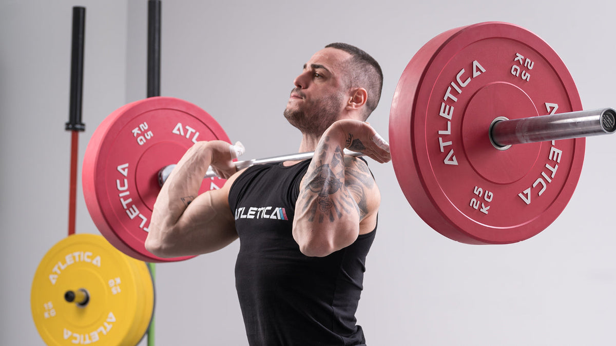 Athlete barbell training with an Atletica barbell and red Color Bumper Plates