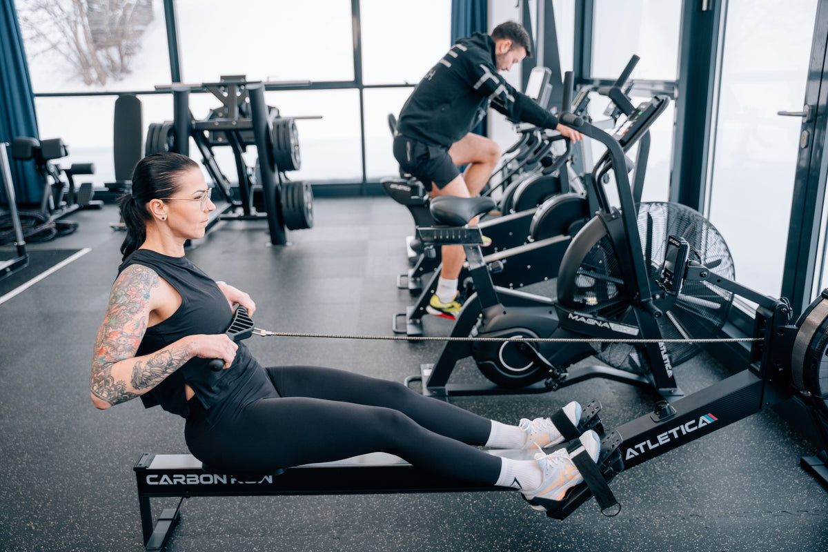 Frau beim Rudern am Atletica CarbonRow Rudergerät im Functional Fittnessstudio