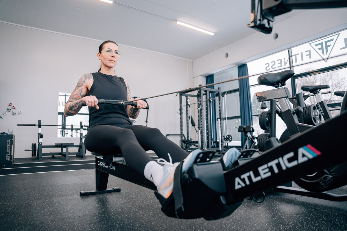 Frau beim Rudern am Atletica Rudergerät im Fitnessstudio