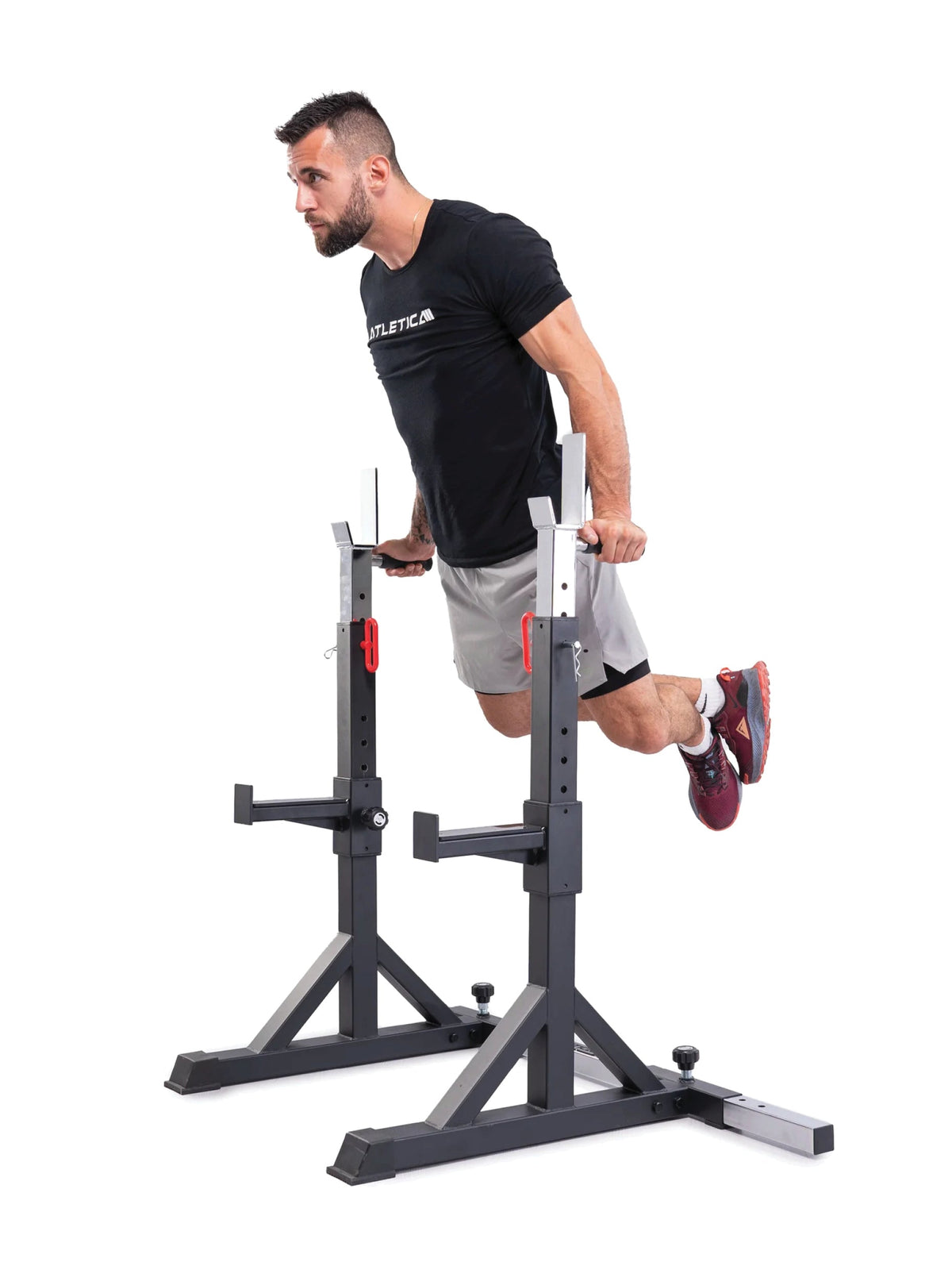 Man doing dips on the Atletica free-standing squat stands