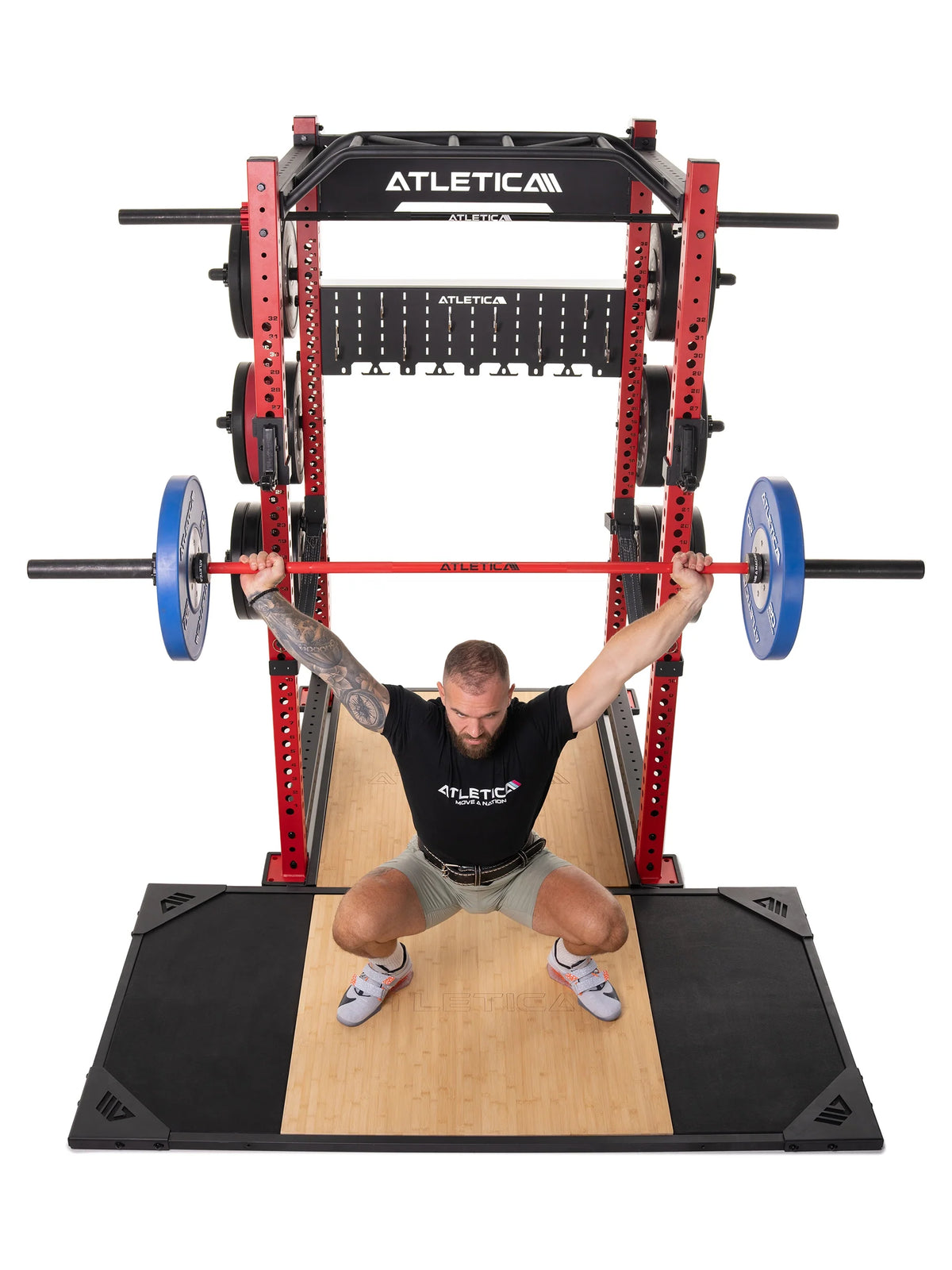Man doing overhead squats with a barbell on the Atletica deadlift platform, front view