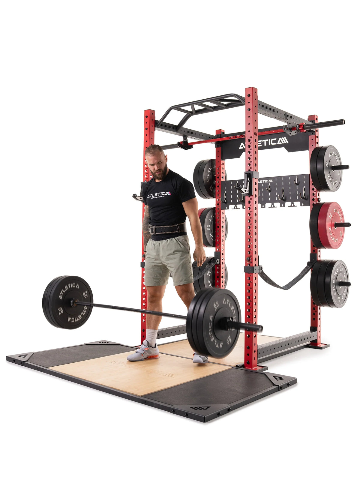 Man deadlifting on the Atletica T-shape deadlift platform next to a red power rack
