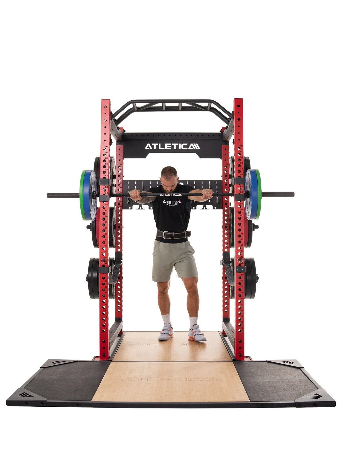 Man holding a barbell in front rack position on the Atletica deadlift platform