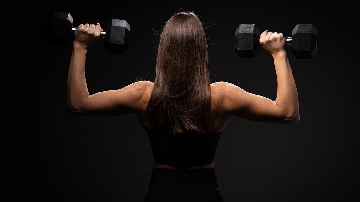 Woman holding two hex dumbbells
