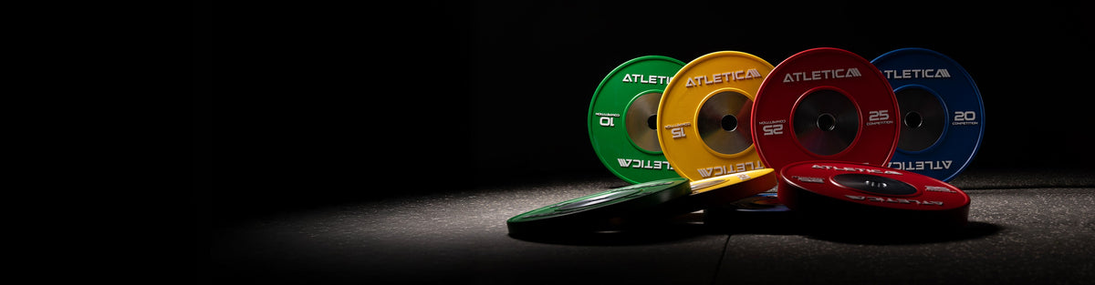 Atletica competition bumper plates in green, yellow, red, and blue