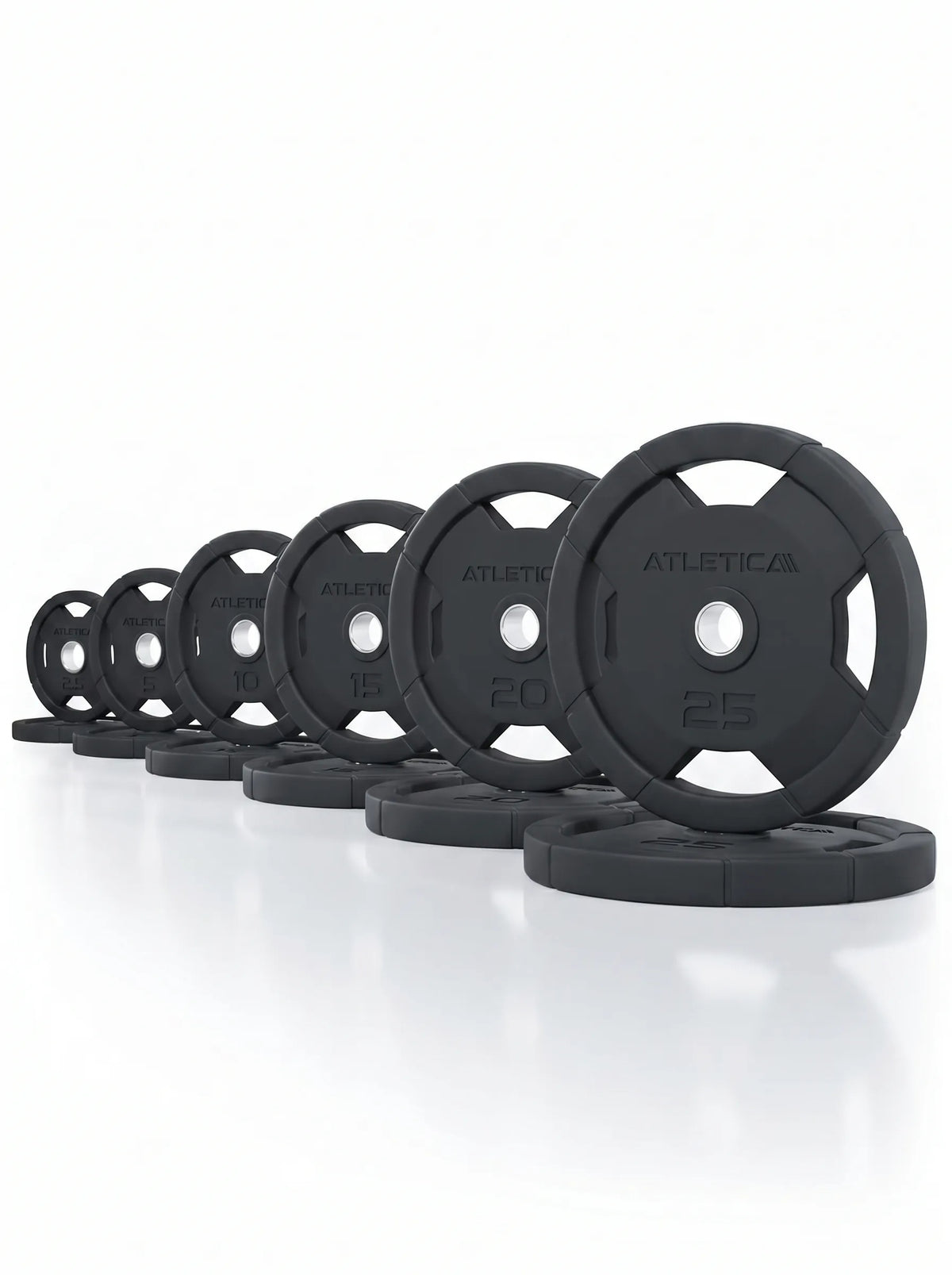 Black rubber-coated Atletica weight plates lined up by size for the Harrier functional trainer