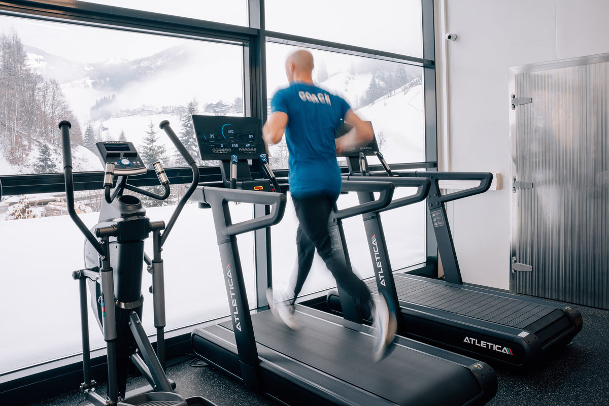 Personal Trainer beim Laufen auf dem Runmaster Laufband von Atletica im Fitnessstudio