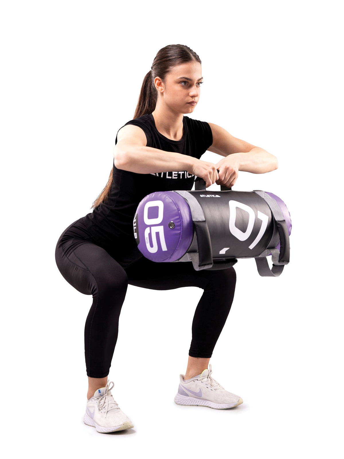Woman doing squats holding two Atletica power bags in a goblet position