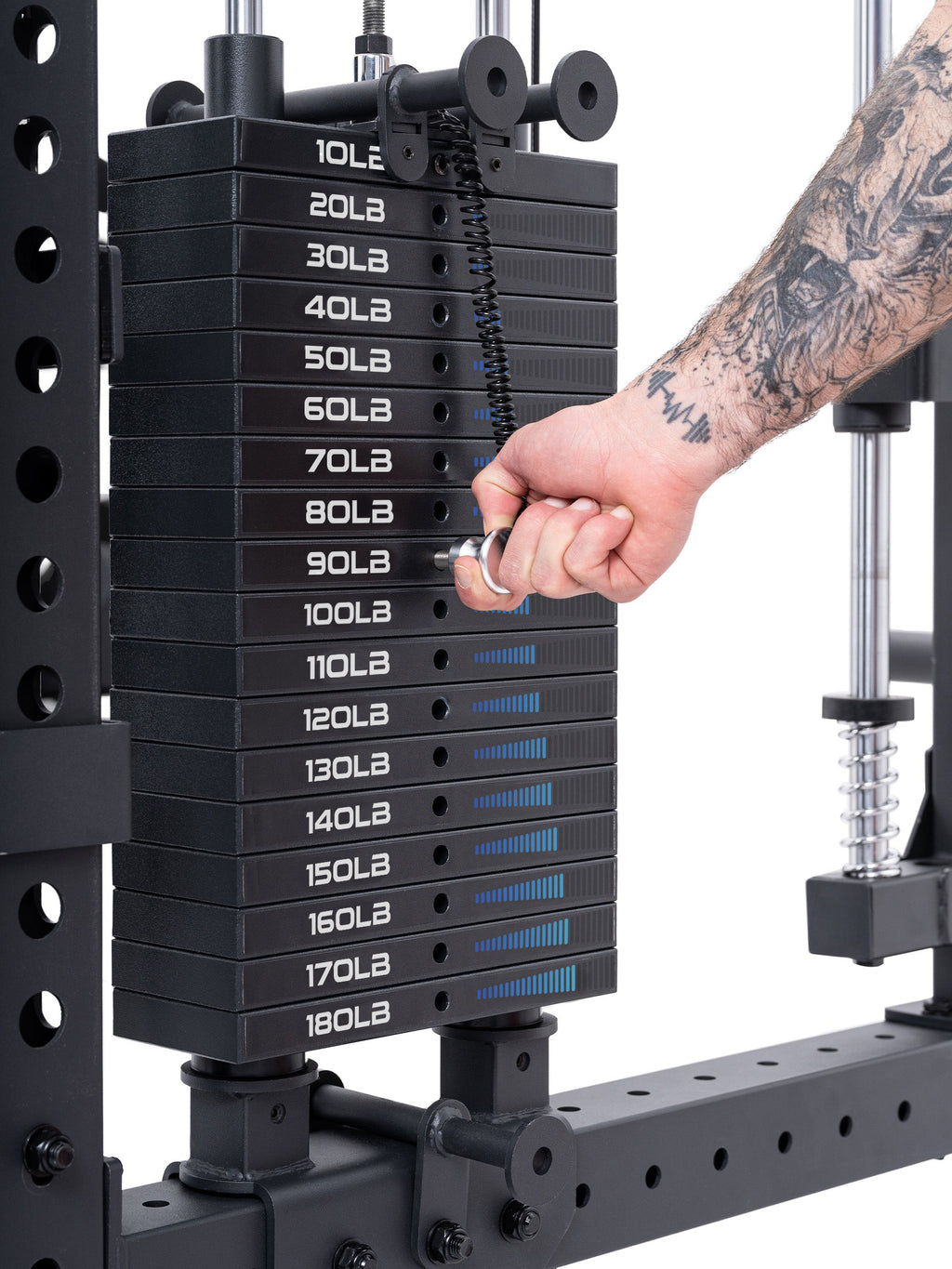 Close-up of a weight stack (10 to 190 lb) on the Atletica R8 Bradley Power Rack, with a hand inserting the pin at 100 lb