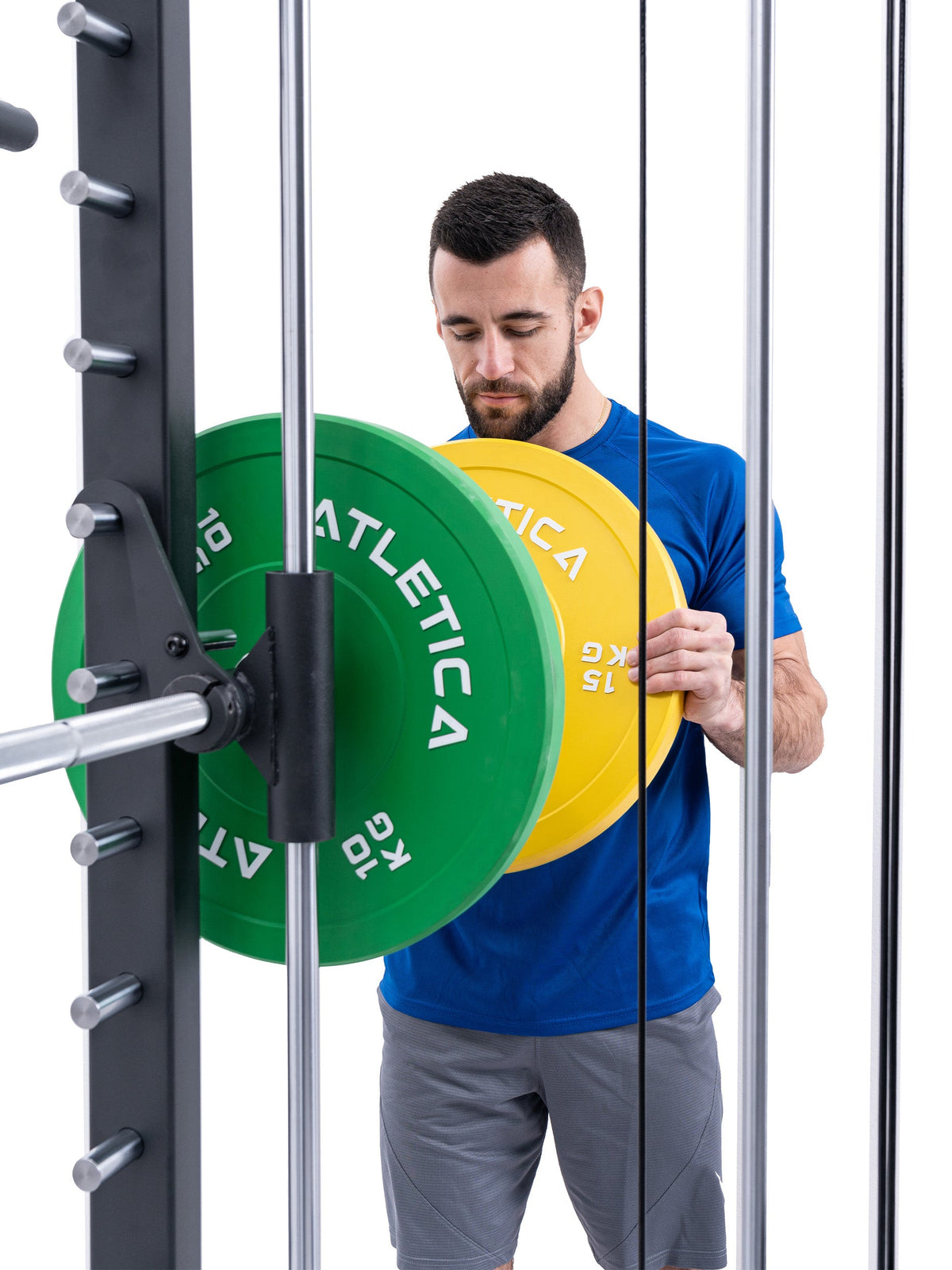 Athlete loading the R8 Bradley Power Rack with a green 25 lb and a yellow 35 lb Bumper Plate