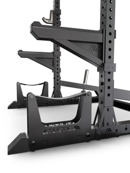 ATLETICA R7 Half Rack – close-up of deadlift station, spotter arms and plate storage