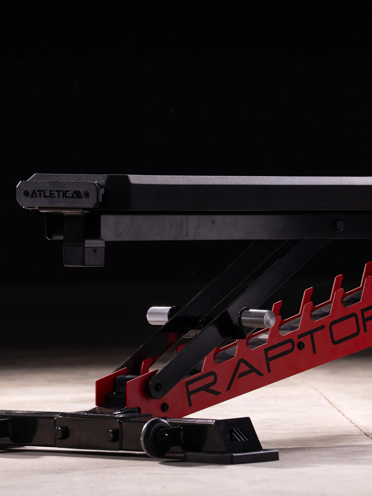 Atletica Raptor HexPad weight bench, low side view of the red toothed adjustment rail
