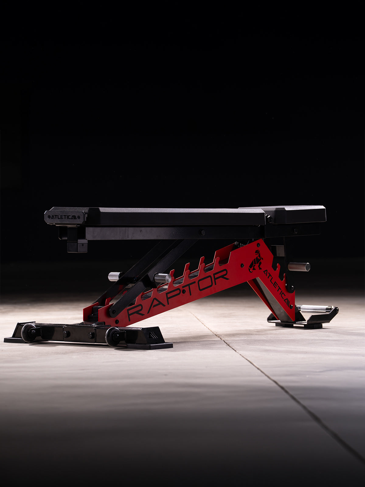 Atletica Raptor HexPad weight bench in sports car red, flat position, side view on a dark background