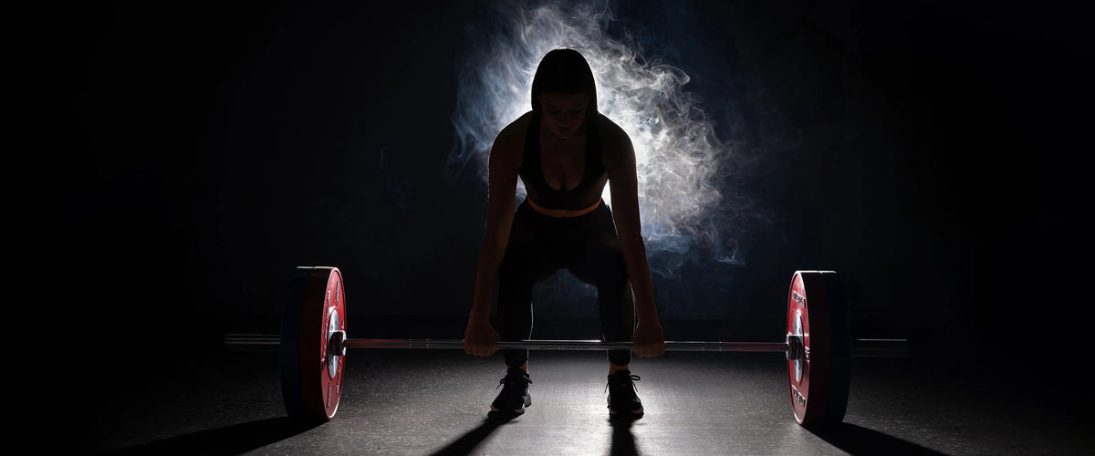 Athletin beim Kreuzheben mit Langhantel und Competition Bumper Plates Gewichten